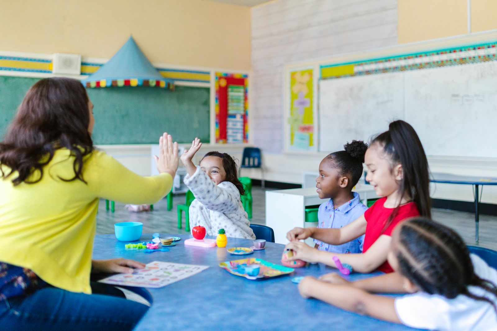 Educadora e crianças em sala de aula inclusiva