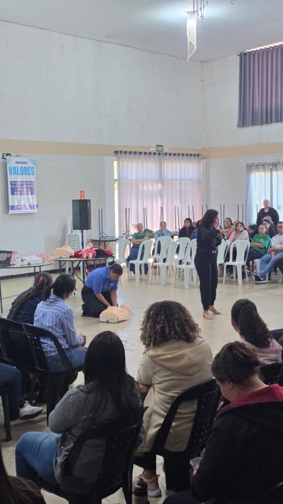 Instrutora demonstrando manobra de primeiros socorros em boneco de treinamento